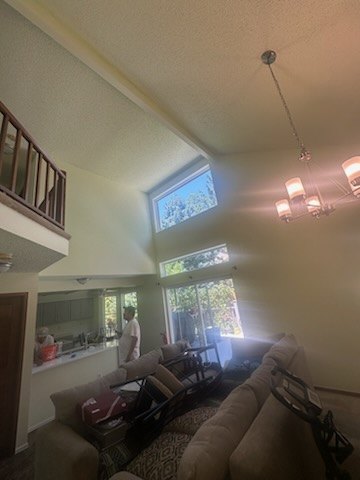 Finished living room with a vaulted ceiling, clean paint and natural light